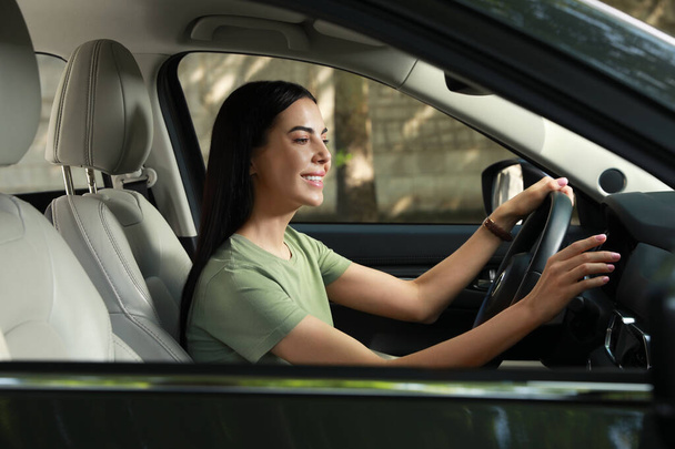 Young woman using navigation system while driving car - Foto, Imagen