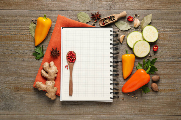 Blank recipe book and different ingredients on wooden table, flat lay. Space for text - Foto, Imagen