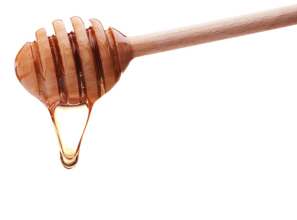 Honey dripping from a wooden honey dipper - Foto, Imagen