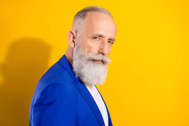 Profile side photo of charming serious attractive old man wear blue blazer isolated on yellow color background - Foto, Imagen