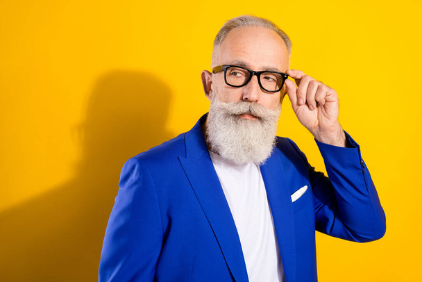 Photo of strict grey beard elder man look empty space wear spectacles blue jacket isolated on vivid yellow color background - Φωτογραφία, εικόνα