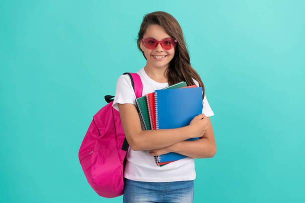 Z powrotem do szkoły. Dzień wiedzy. edukacja. Dzieciak w okularach trzyma książkę z kopiami. 1 września. - Zdjęcie, obraz