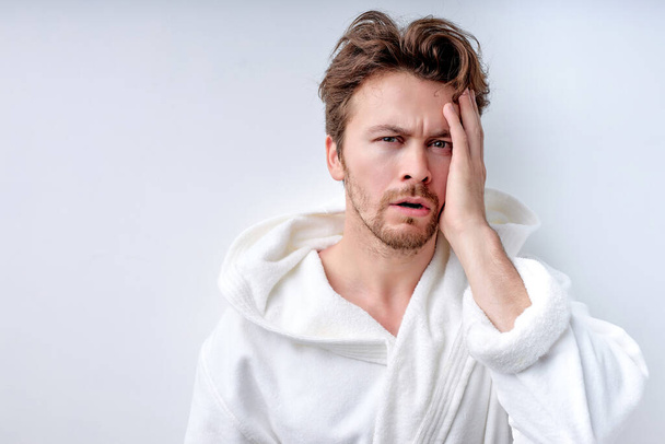 Young caucasian man suffering migraine while standing over isolated white background - Photo, image