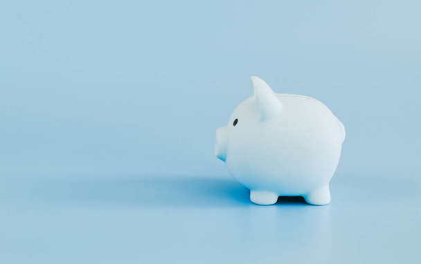 A blue piggy bank stands on the right against a blue background with space for text on the left, close-up side view. - Photo, Image