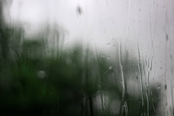 Regendruppels op het raam, regenachtige dag. Achtergrond regendruppels. wazige achtergrond - Foto, afbeelding