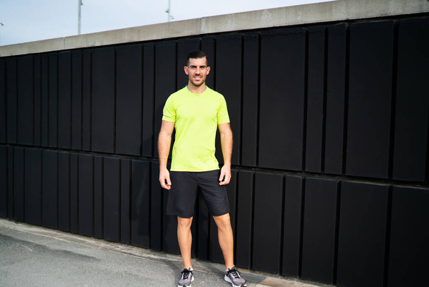 Full length portrait of successful male athlete in sportswear looking at camera during morning time for cardio training at urban setting, Caucasian muscular runner with perfect body shape posing - Photo, image