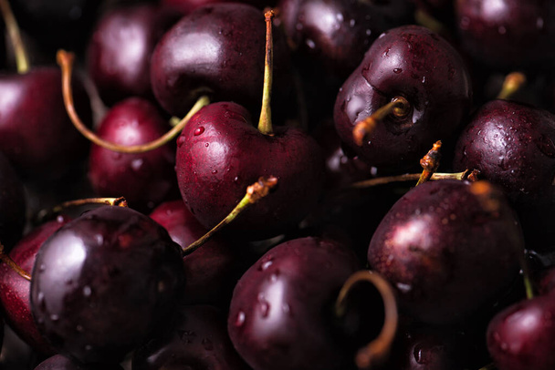 Close up of a pile of ripe sweet cherries with stalks. - Photo, Image