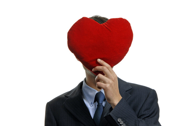 Man holding covering his face with a red heart - Фото, изображение