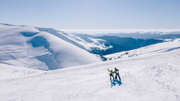 pár síelő és snowboardos a hegy tetején a napsütéses téli vakáció - Fotó, kép