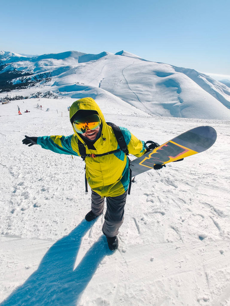 ember snowboard a hegy tetején gyönyörű kilátás nyílik a háttérben - Fotó, kép