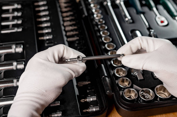 Car repair tools in male hands closeup over toolkit with mechanic instruments. - Fotó, kép