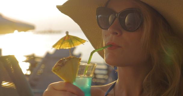 Donna in Cappello e Occhiali da Sole Bere Cocktail - Foto, immagini