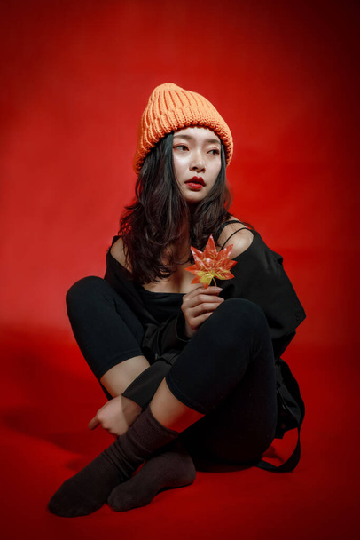 beautiful young woman in halloween costume with red lips and black hat posing in studio - 写真・画像