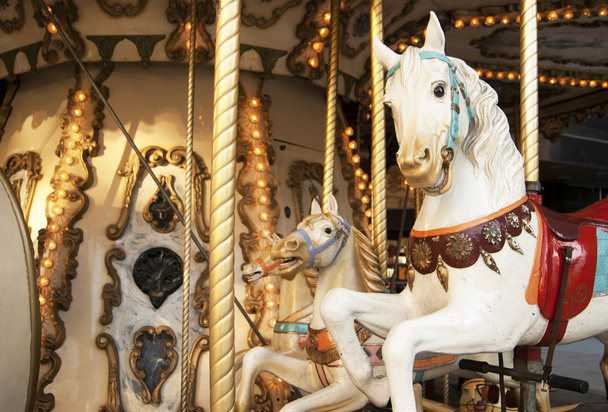 Karuselli ja hevoset lämpimässä sävyssä
 - Valokuva, kuva
