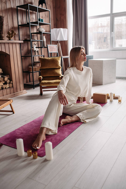 Pretty young calm female meditating relaxing sitting on natural mat in cozy home interior on weekend. Womans wellness - Photo, Image