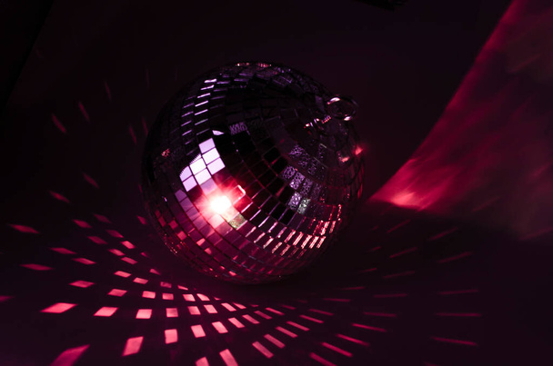 Bola de disco brilhando em luz vermelha. festa bola Deitado no escuro - Foto, Imagem