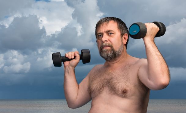 Az ember súlyzókkal gyakorol - Fotó, kép