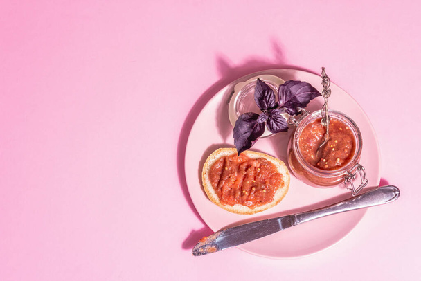 Τσάτνεϊ από ραβέντι. Νόστιμο φαγητό, παραδοσιακή εποχική σάλτσα. Pastel ροζ φόντο, σύγχρονο σκληρό φως, σκούρα σκιά, top view - Φωτογραφία, εικόνα