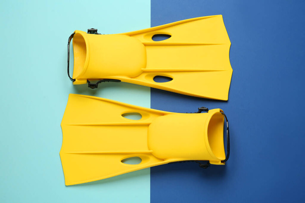 Pair of yellow flippers on color background, flat lay - Fotó, kép