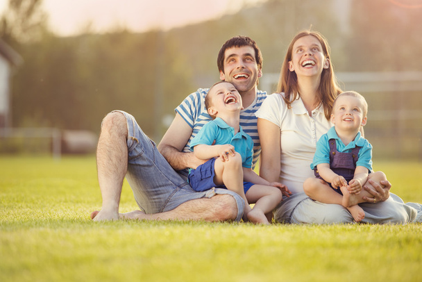 Family sitting on football pitch - Фото, изображение