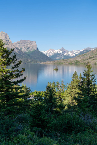 Wild Goose Island in Glacier National Park, on a sunny day with calm water - Fotó, kép