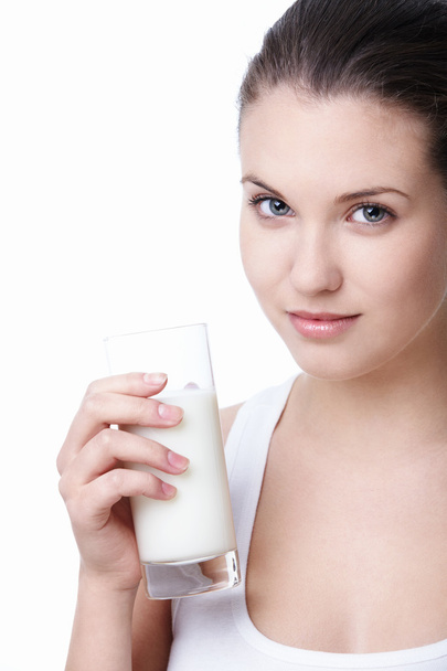 Attractive young girl with a glass of milk on a white background - Φωτογραφία, εικόνα