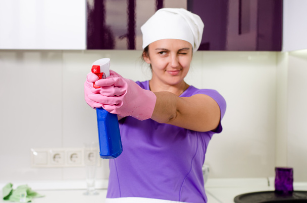Juguetón ama de casa apuntando con el detergente
 - Foto, imagen