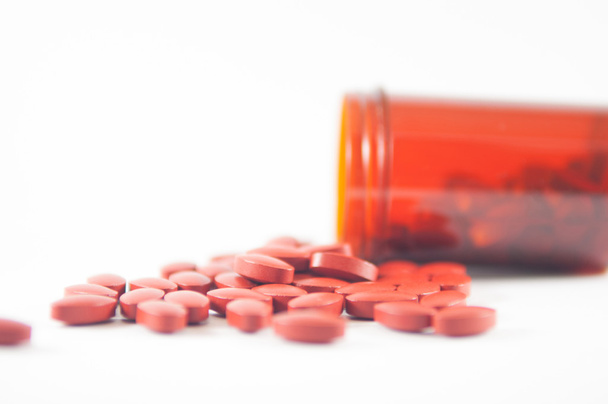 Ruskea tabletti lääkepullon taustalla
 - Valokuva, kuva