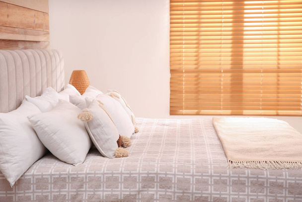 Удобная кровать с мягкими подушками в номере отеля - Фото, изображение