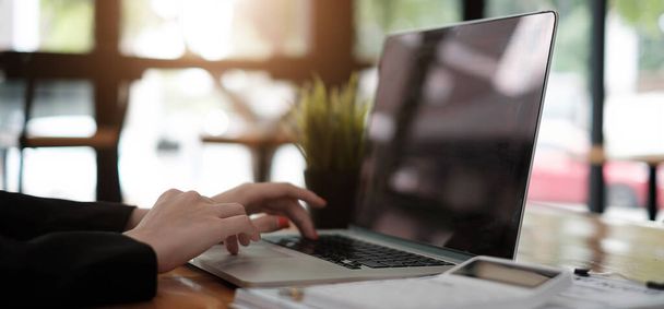 Aziatisch meisje werken op een kantoor tijdens het gebruik van laptop computer voor financiële analyse, belasting, kosten - Business Financial Concept - Foto, afbeelding