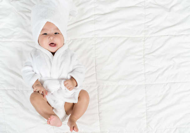 happy baby in soft bathrobe on a bed - Foto, Imagem