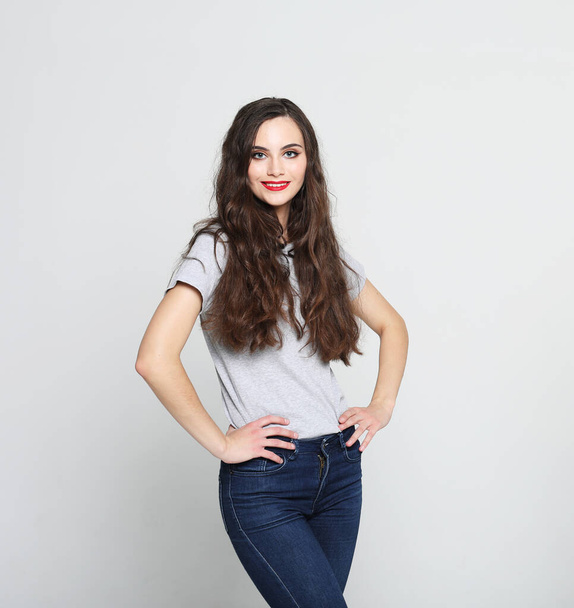 Young woman wearing casual clothes, posing on grey background - Φωτογραφία, εικόνα