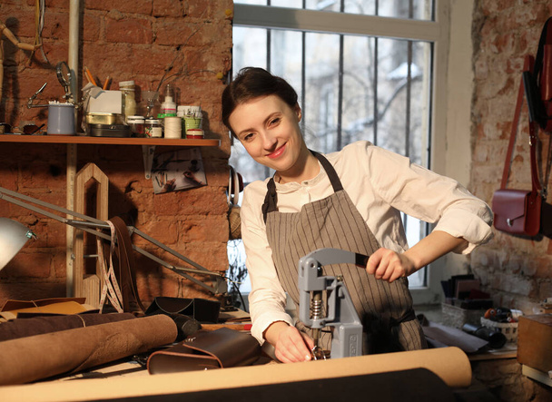Leather handbag craftsman at work in a vintage workshop. Small business concept. - Photo, image