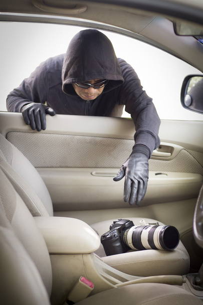 Thief stealing camera  from car - Photo, Image