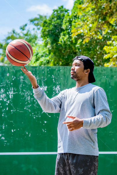 Uomo che si allena all'aperto al sole giocando a basket durante la crisi del COVID-19, 26 giugno 2021, Surat Thani, Thailandia. - Foto, immagini