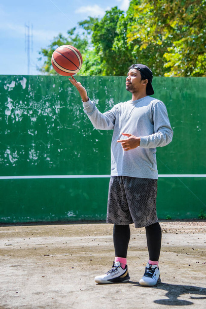 26 Haziran 2021 'de COVID-19 krizi sırasında dışarıda basketbol oynayarak egzersiz yapan adam, Surat Thani, Tayland. - Fotoğraf, Görsel