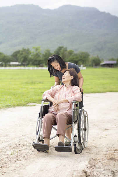 アジア系の若いはファームで車椅子を年配の女性の世話をして - 写真・画像