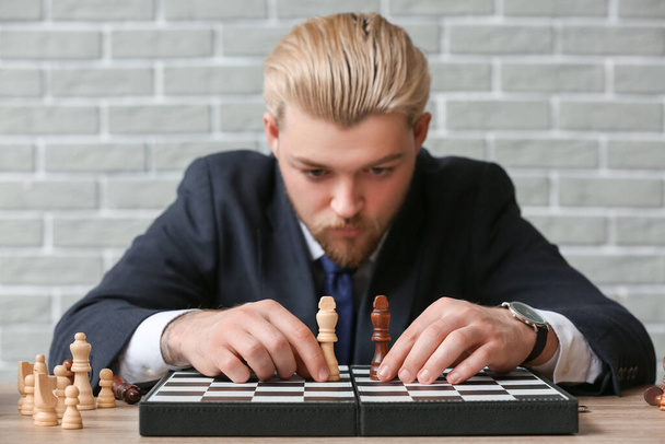 Man with chess pieces on game board, closeup - Photo, Image