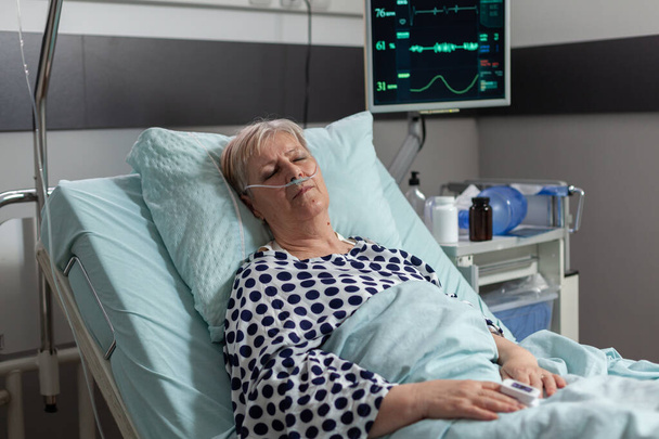 病院のベッドに横になった回復治療後の高齢患者 - 写真・画像