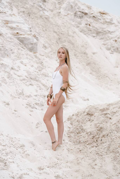 若いです細い美しいですスリムセクシー女性でホワイト水着ボディスーツ上の白い砂の上にビーチとともに - 写真・画像
