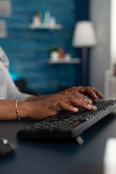Primer plano de las manos de los estudiantes negros que escriben en el teclado que navega información en línea en Internet - Foto, imagen