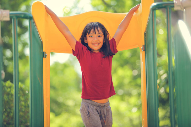 Щаслива смішна маленька дівчинка, що веселяться, ходить на дитячому майданчику на відкритому повітрі в денний час літа. Активність на відкритому повітрі. Гра робить віру і зовнішню концепцію освіти
. - Фото, зображення