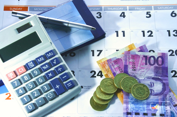 Calendário, livro de cheques, calculadora, dinheiro e uma esferográfica
 - Foto, Imagem