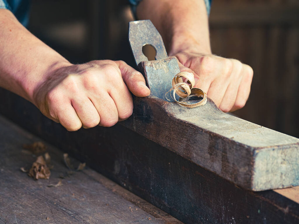 Der Schreiner mit dem Handhobel für die Holzbearbeitung in seiner Werkstatt - Foto, Bild