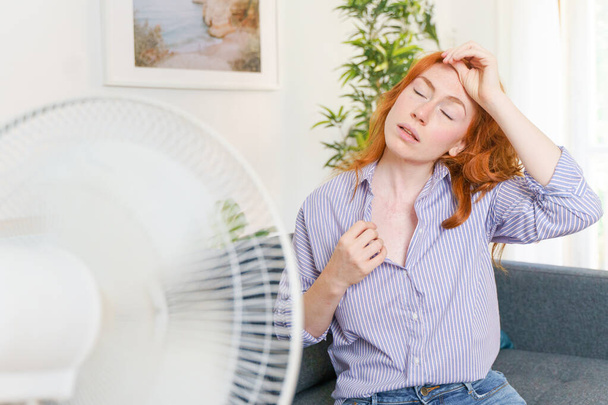 Μια γυναίκα υποφέρει από ζέστη την καλοκαιρινή περίοδο. - Φωτογραφία, εικόνα