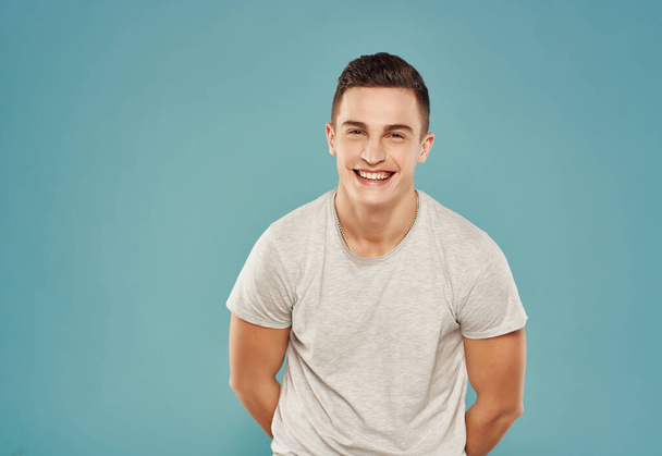 handsome man in t-shirt gesturing with his hands cropped view blue background - Photo, Image