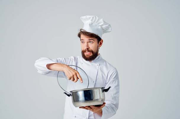 Cheerful chef with saucepan in hand in  kitchen cooking  - Фото, зображення