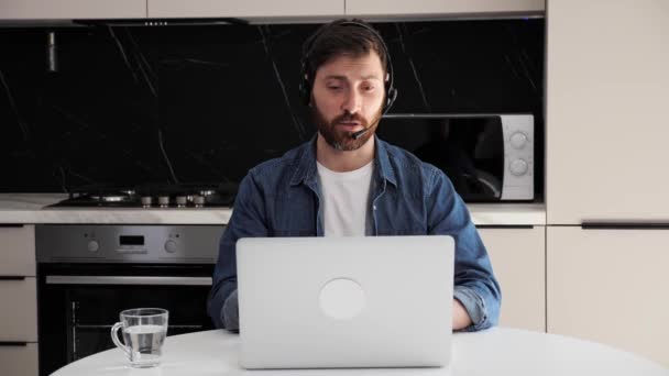 Liikemies käyttää kuulokkeita puku video konferenssi soittaa kotona. - Materiaali, video
