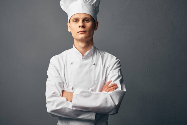 chef masculino con una gorra blanca sostiene sus manos delante de él profesionales de confianza en sí mismo - Foto, imagen