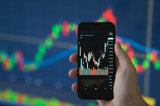 Close up shot of real time stock trading on smartphone in his hands - Foto, Bild